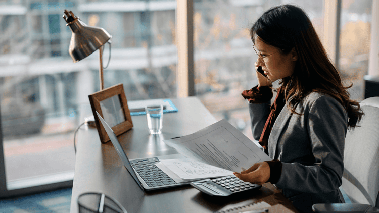 asian-businesswoman-talking-on-cell-phone-while-working