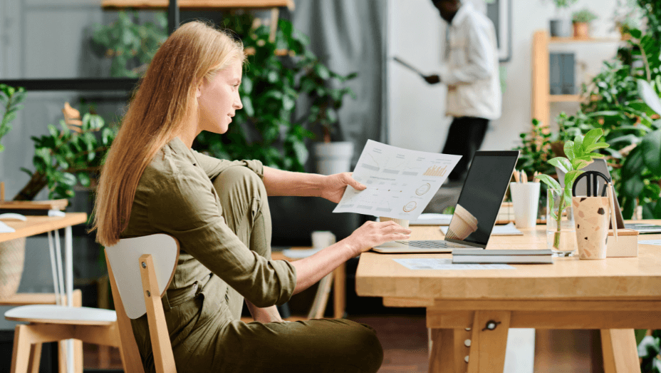 Side view of young businesswoman with long blond hair analyzing data