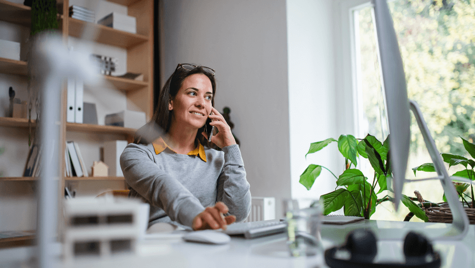 businesswoman sitting at the desk indoors in office, working