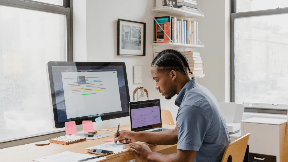 man writing a note working remote