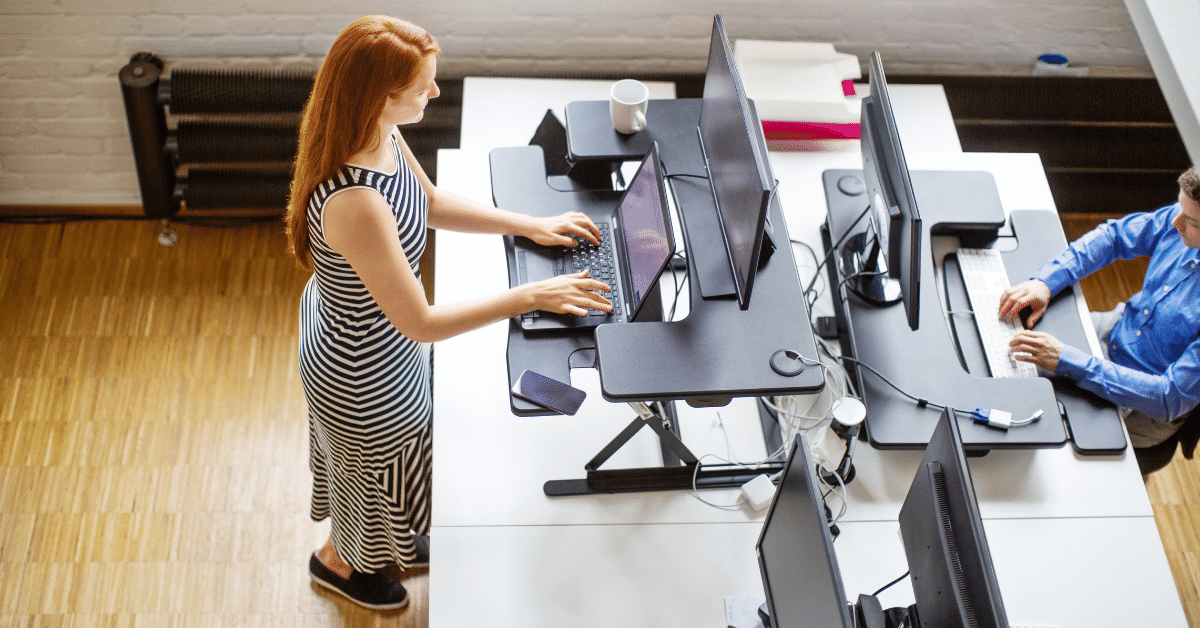 A worker using a standing desk at the office