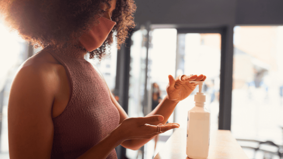businesswoman-using-hand-sanitizer-before-entering-office