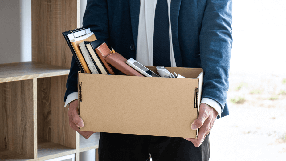 a resigned employee packing his belongings and leaving office