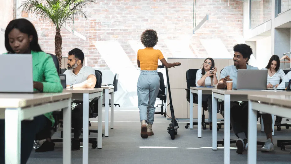 young African American woman with electric scooter at office