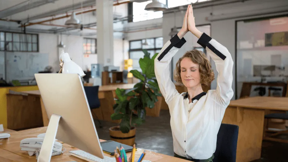 female graphic designer performing yoga in the office
