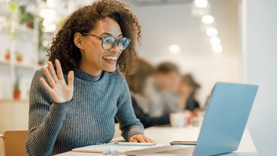 smiling african woman talking with colleagues by video
