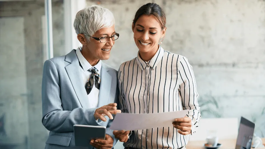 Businesswomen cooperating while analyzing reports