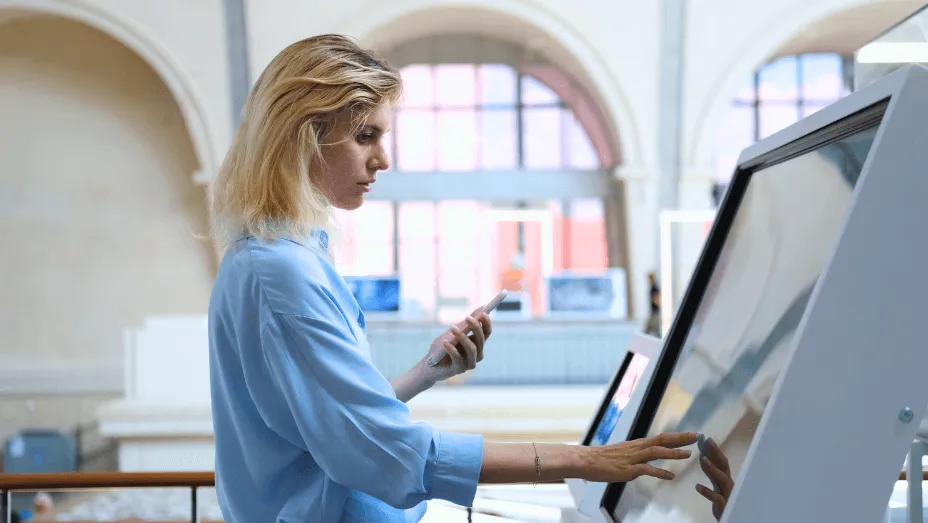 Female employee using a digital screen in the lobby