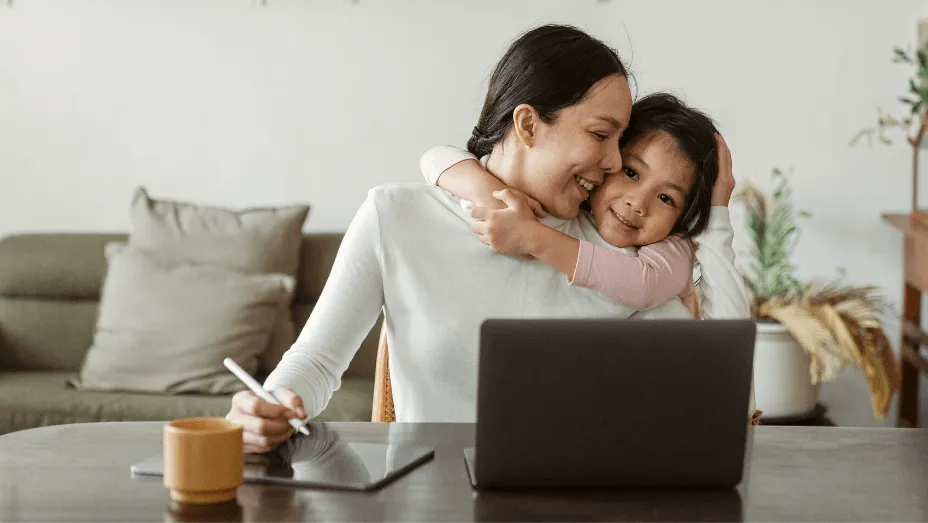 Cute little girl embracing working mother