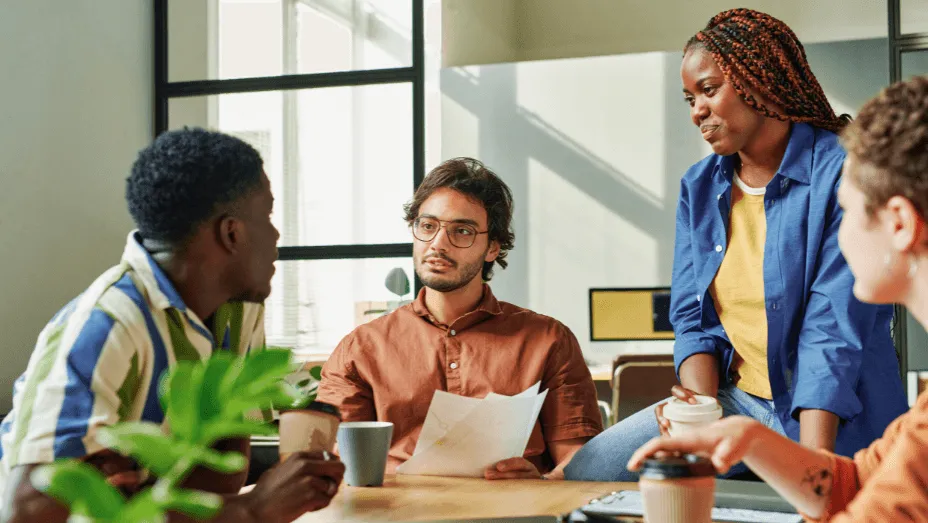 young confident manager with papers talking to colleagues